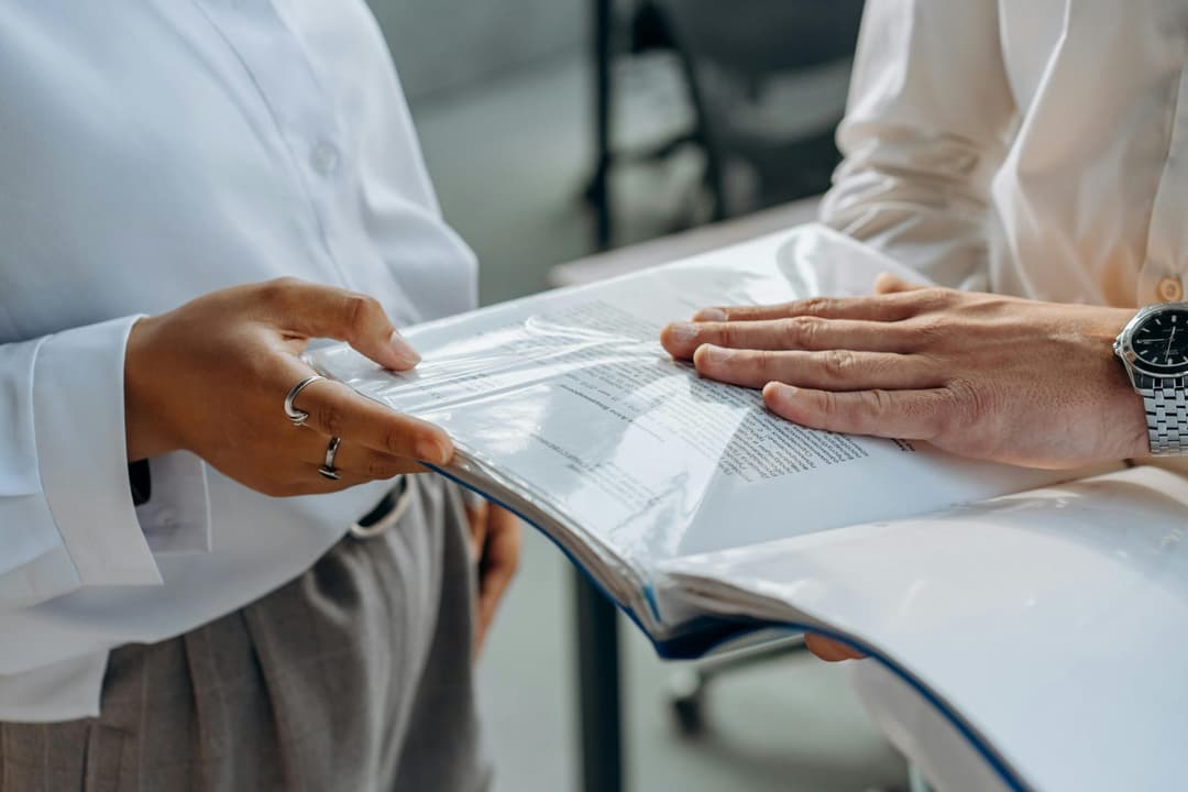 Unterlagen zu Sozialplan und Abfindung für Mitarbeiter auf dem Schreibtisch
