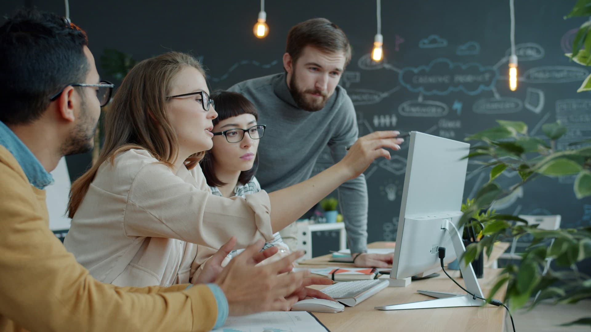 Start-up-Team bespricht sich im Büro am Computer