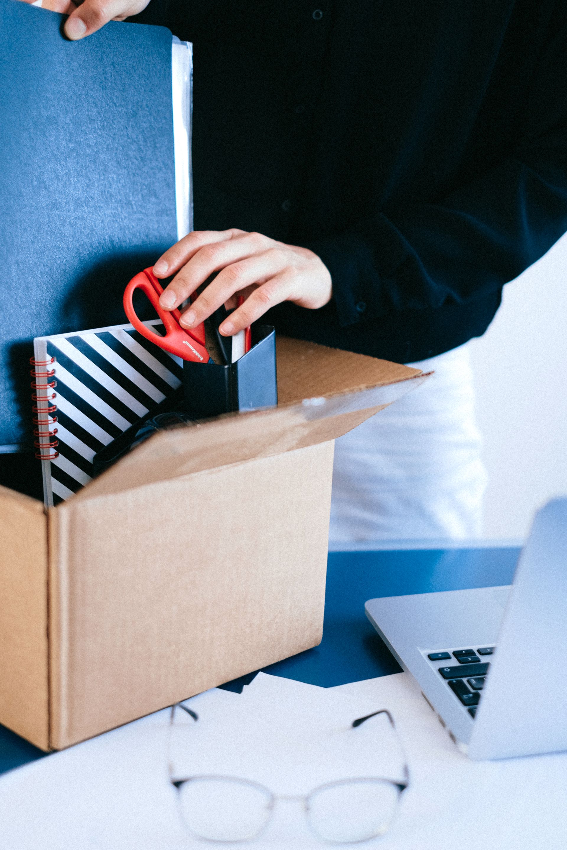 Arbeitnehmer packt persönliche Gegenstände in eine Kiste nach einer Kündigung