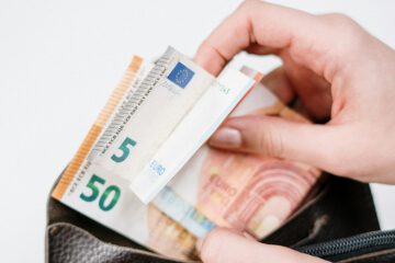 Geldscheine mit Brieftasche als Symbolbild für Lohnrückstand und Verzug beim Gehalt